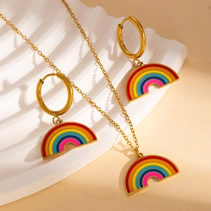 Close-up of rainbow pendant jewelry set including gold necklace and hoop earrings