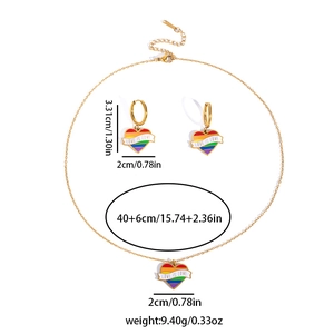 Detail view of gold rainbow heart necklace set with Love Is Love enamel pendant and earrings