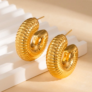 Macro detail of gold plated 18K hollow C-shape earrings with ribbed texture design
