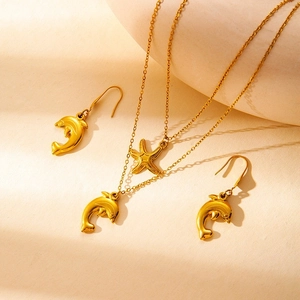 Set di gioielli dorati con collana a delfino e stella marina e orecchini a gancio