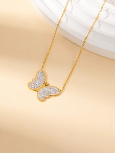 Close-up of a gold butterfly necklace with crystal micro-pave detailing on a stone base