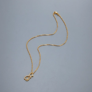 Détail du collier à chaîne torsadée dorée avec pendentif anneaux entrelacés et zircons