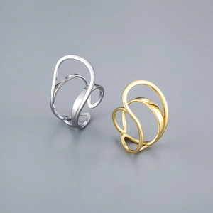 Detalle de anillos geométricos huecos superpuestos en acabado oro y plata