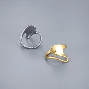 Detailweergave van onregelmatige gepolijste goud en zilver ringen met geometrisch design