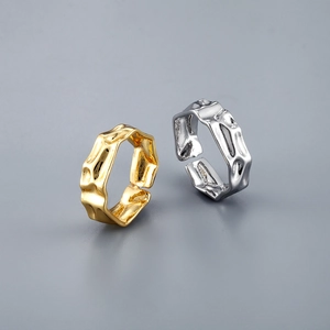 Anillos de ondas irregulares en oro y plata con superficie texturizada y diseño abierto