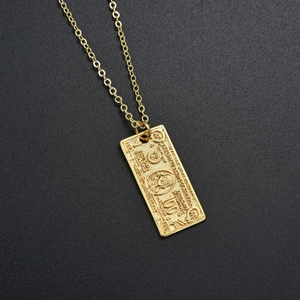 Close-up of gold-plated 100 dollar bill pendant with detailed Benjamin Franklin engraving