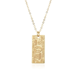 Detail of gold $100 bill pendant necklace featuring intricate embossed textures and text