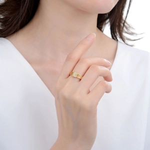 Primo piano di un anello dorato a più strati con blocco rettangolare in pavé di diamanti