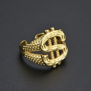 Detailed close-up of golden dollar sign ring featuring intricate engraved textures and relief