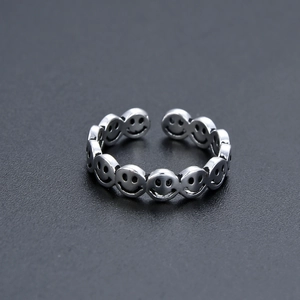 Macro shot of retro sterling silver ring with continuous smiling face pattern