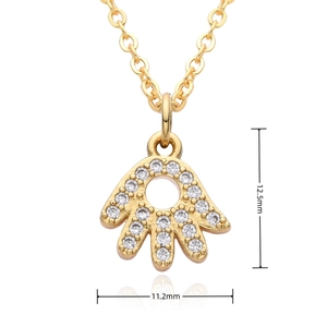 Macro view of small gold Hamsa Hand pendant measuring 12.5mm by 11.2mm with clear stones