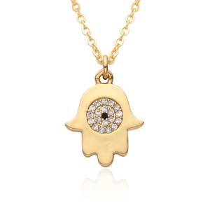 Close-up of golden Hamsa hand pendant necklace with evil eye and white sparkling crystals