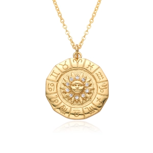 Macro view of gold sun pendant featuring facial relief, zircon settings and zodiac symbols