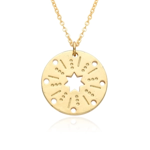 Detailed close-up of golden round sunburst pendant with starburst engraving and thin chain