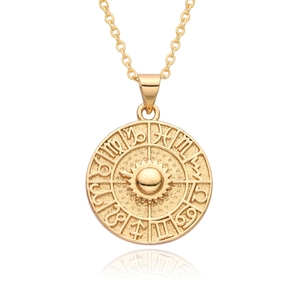 Detail of 18K gold-plated coin pendant with celestial sun and zodiac constellation symbols