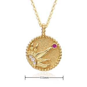 Detail view of a 17.5mm gold coin pendant with red gemstone and beaded edge