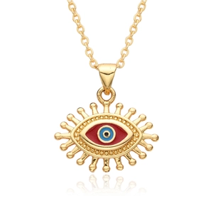 Macro detail of gold-plated evil eye pendant with blue resin and sunburst rays