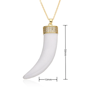 Gros plan du pendentif corne blanche de 58mm avec calotte dorée sertie de zircons