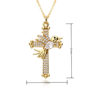 Détail macro du pendentif croix dorée et oiseau avec dimensions 31mm hauteur et 19mm largeur