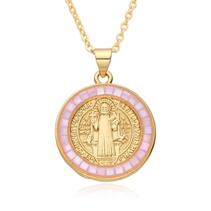 Detailed macro view of gold religious pendant with pink mother-of-pearl and St. Benedict medal