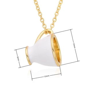Gros plan d'un petit pendentif tasse dorée mesurant 13 mm de haut et 12 mm de large