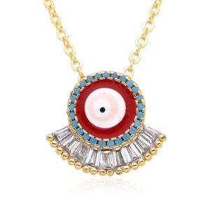 Collier vintage œil du mal doré avec émail rouge et perles turquoise sur fond blanc