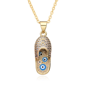 Detailed macro view of gold slipper pendant with micro-pave zircons and evil eye charms