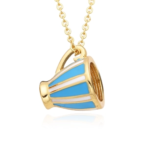 Gros plan du pendentif tasse à thé dorée avec émail bleu et chaîne fine en métal doré