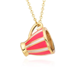 Gros plan du pendentif tasse en émail rouge et blanc sur un collier pull en chaîne dorée