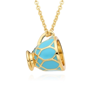 Détail du pendentif théière dorée avec émail bleu et texture florale sur chaîne
