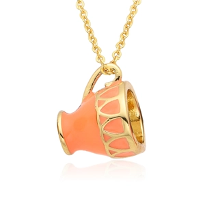 Detailed close-up of orange enamel teacup pendant with gold geometric openwork patterns