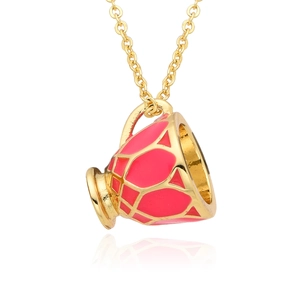Vue macro détaillée d'un pendentif théière en émail rouge avec chaîne dorée