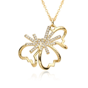 Détail macro du pendentif papillon doré avec zircons blancs sertis et fine chaîne croisée