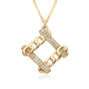 Gros plan d'un collier pendentif géométrique doré serti de zircons blancs sur fond blanc