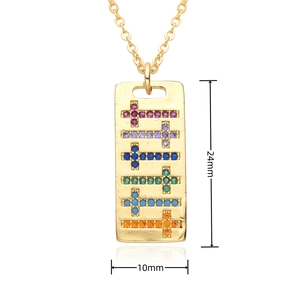 Vue détaillée d'un pendentif rectangulaire doré orné de six mini pierres précieuses en croix