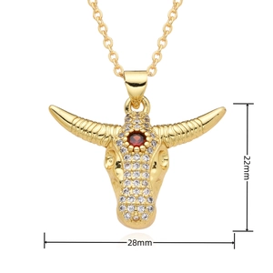 Dettaglio del ciondolo a testa di toro in oro 18k con pavé di zirconi e pietra rossa