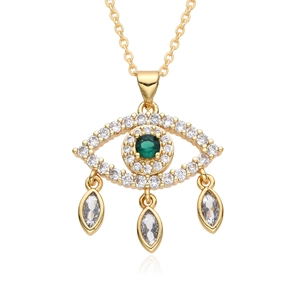 Détail du collier Mauvais Œil doré avec cristal vert et trois pendentifs marquise