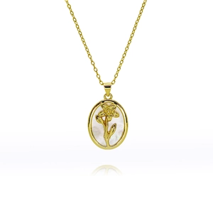 Vue macro du pendentif ovale doré avec nacre blanche et détail de fleur 3D raffiné