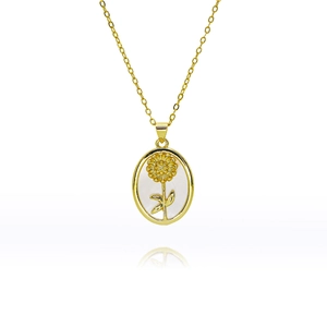 Vue macro du pendentif tournesol doré ovale avec incrustation en nacre blanche irisée