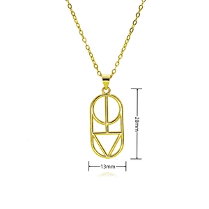 Macro shot of 28mm gold oval pendant with minimalist sunburst and geometric engraving