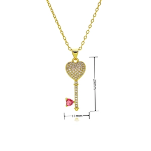 Detailed view of gold-plated heart key necklace pendant with zircon and pink gemstone