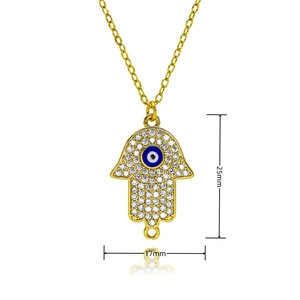 Détail du pendentif main de Fatma dorée avec œil bleu maléfique et pavage de cristaux clairs