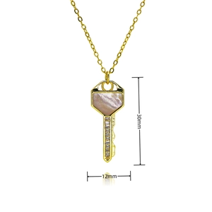 Detail shot of a 30mm gold heart key pendant with pink shell inlay and white zircon stones