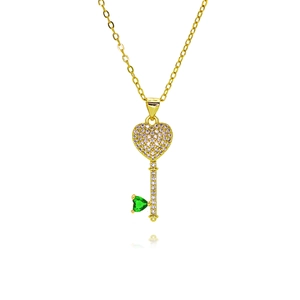 Macro view of gold heart key pendant with white zircon micro-pave and green gemstone