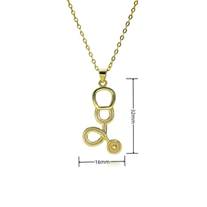 Detail view of the 32mm by 16mm gold stethoscope pendant with pink enamel on an O-chain