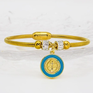 Detailed shot of golden snake chain bracelet with Saint Benedict charm and blue enamel