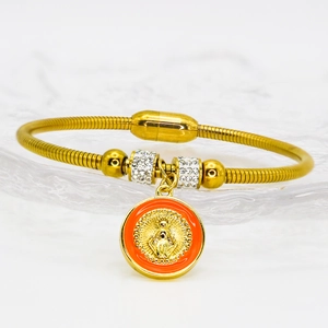 Detail eines religiösen Gold-Anhängers an einem Magnetarmband mit funkelnden Kristallen