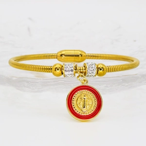 Detail of snake chain gold bangle with red enamel San Benito pendant and crystal beads