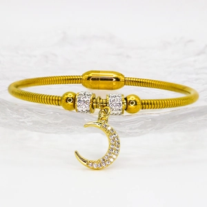 Eleganter Gold-Mond-Armreif mit Kristallen und Magnetverschluss auf Glastablett
