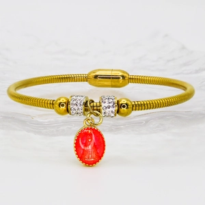 Détail du bracelet chaîne serpent doré avec pendentif religieux émaillé rouge et cristaux